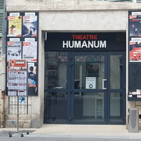 Photo de la façade du théâtre, composée de deux panneaux en bois pour les affiches et d'une porte vitrée au centre.
